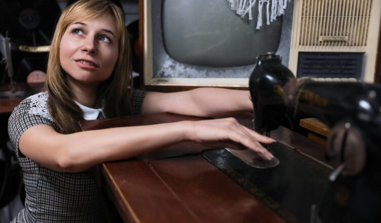 woman posing with vintage tv and sewing machine